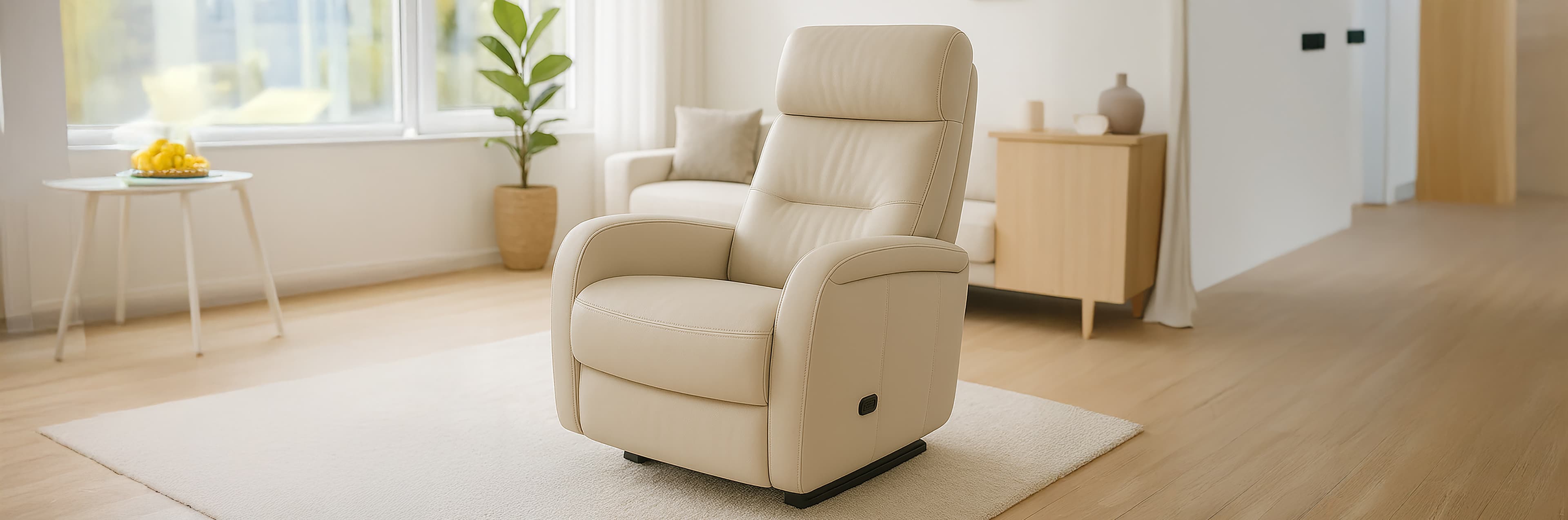 A cream-colored recliner chair sits on a light rug in a bright, minimalist living room with wooden flooring, a small table with lemons, a potted plant, and a cabinet in the background.